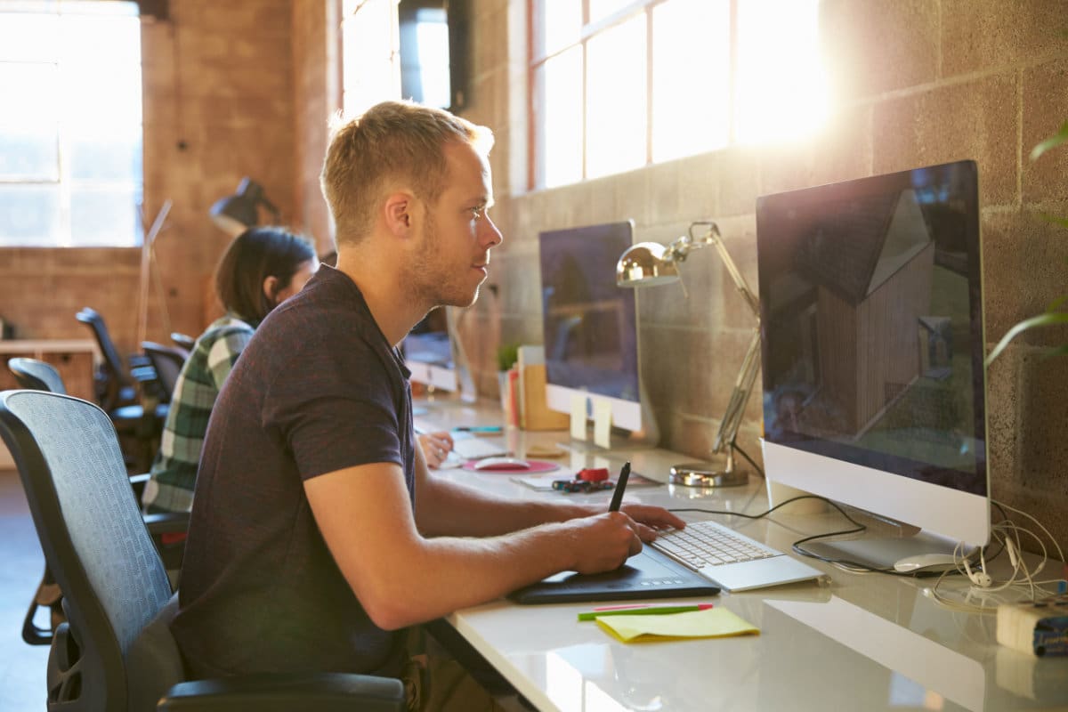 Designers Working At Desks In Modern Office