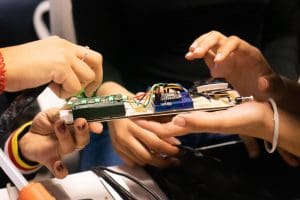 Two students work on an electronic prototype powered by the Particle Photon.